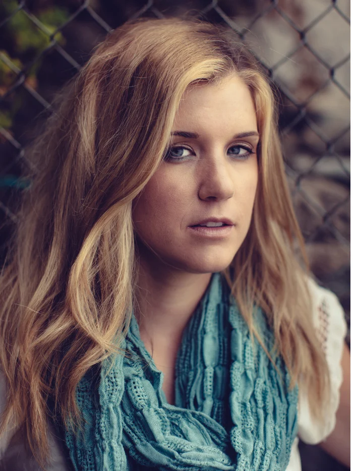 A woman in a teal scarf in a dark sea cave