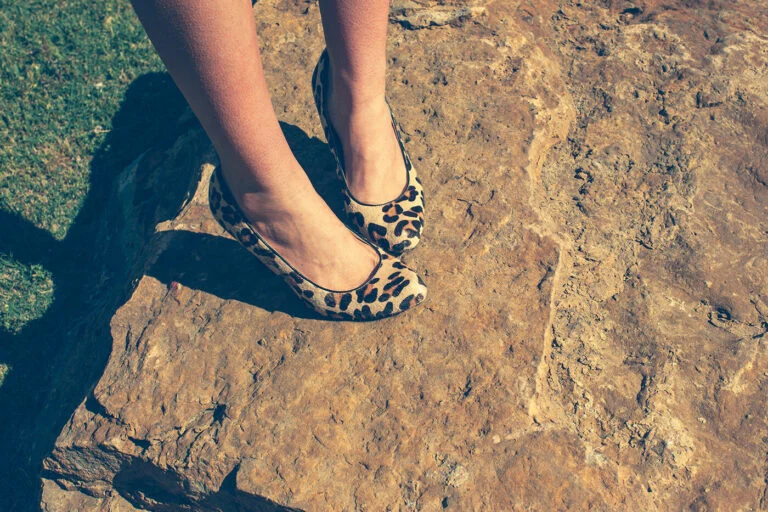 Leopard print flats on a sandstone ledge