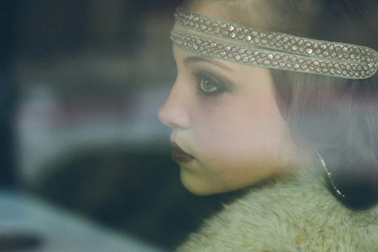 A woman in a beaded headband seen through a car window