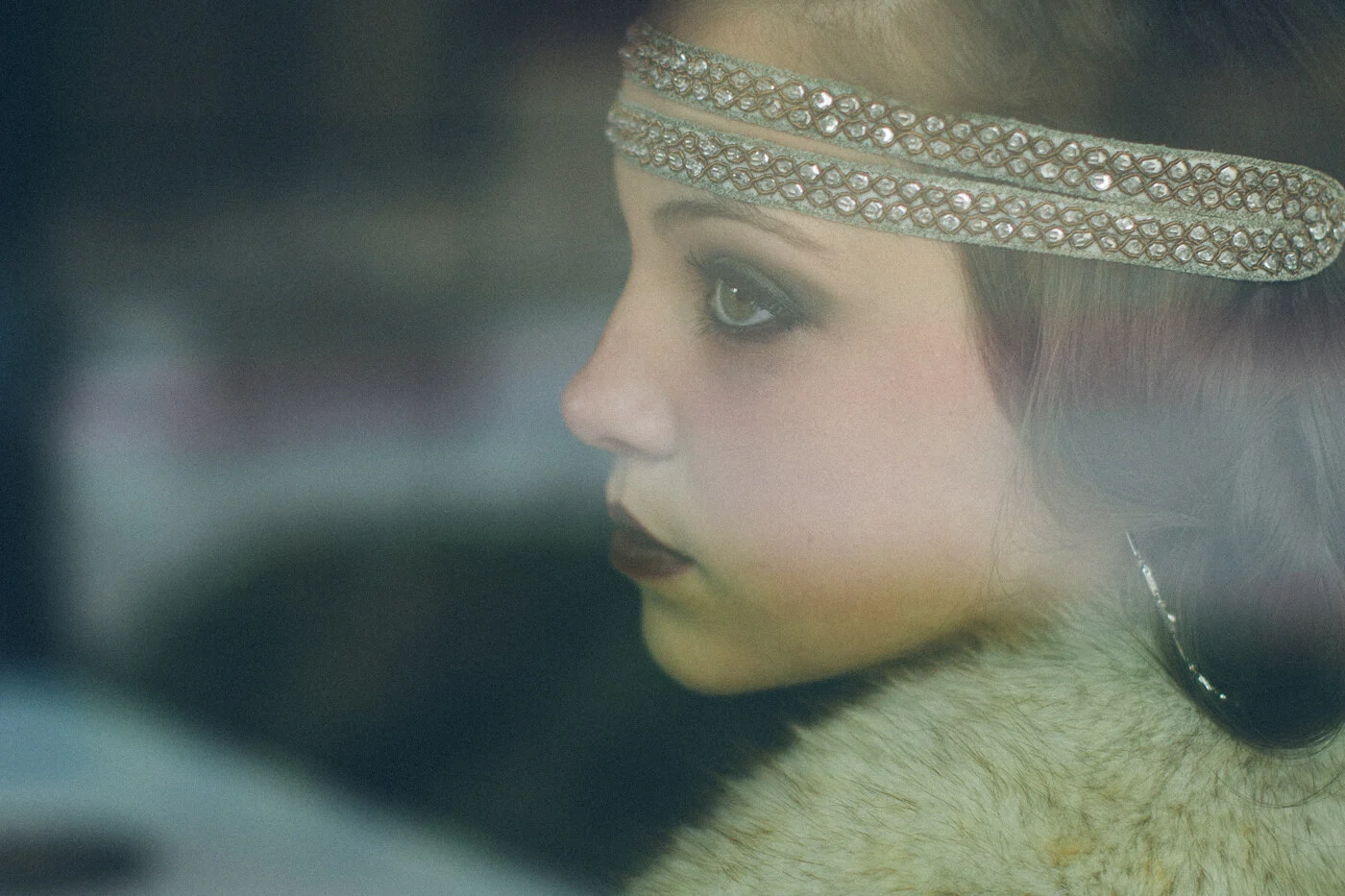 A woman in a beaded headband seen through a car window