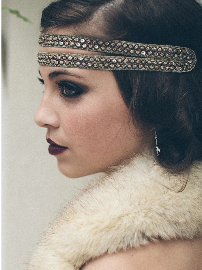 A profile of a woman in a beaded headband and a fur stole